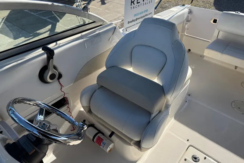 Slide: The Image of 2015 Robalo R227 Dual Console boat interior with steering wheel and seating. - 23