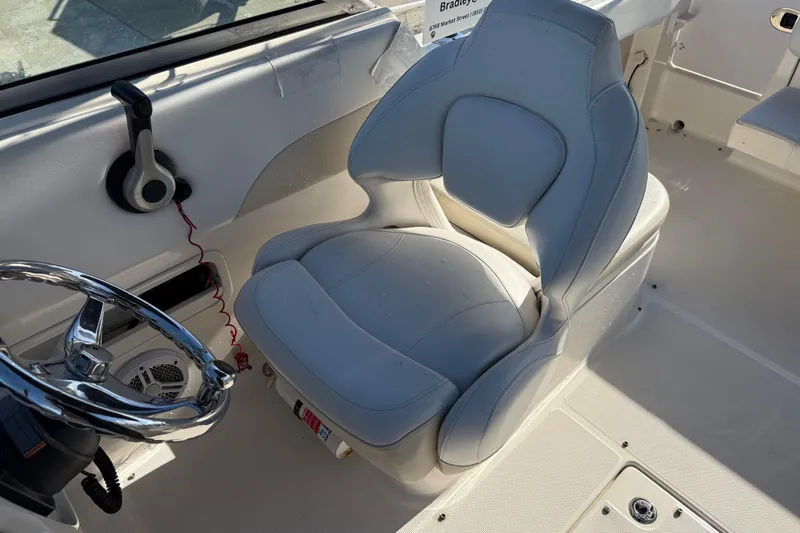 Slide: The Image of 2015 Robalo R227 Dual Console boat interior with steering wheel and captain's chair. - 24