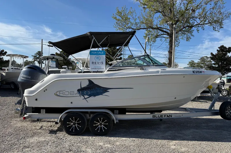 Slide: The Image of 2015 Robalo R227 Dual Console boat on trailer, for sale sign visible. - 7