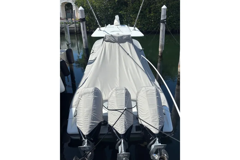 Slide: The Image of 2024 Yellowfin 36 Offshore boat covered at dock with triple outboard engines. - 16