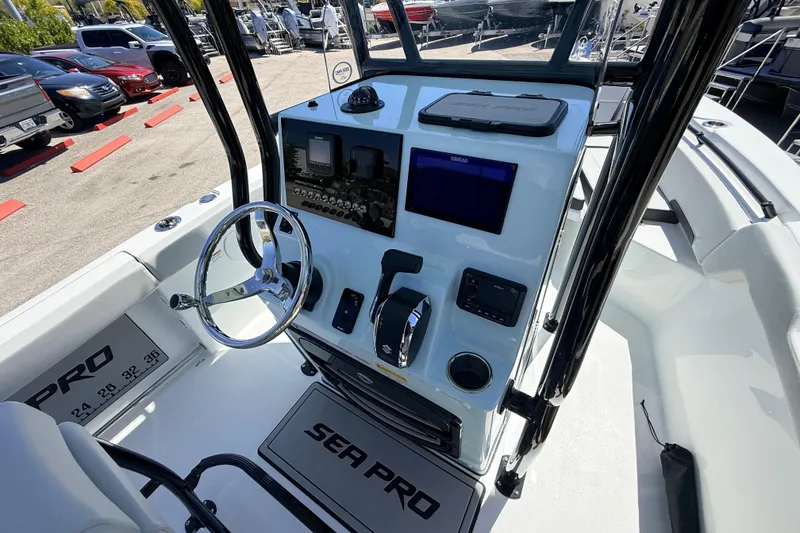 Slide: The Image of 2026 Sea Pro 225FLX Sandbar boat dashboard with steering wheel and navigation controls. - 16
