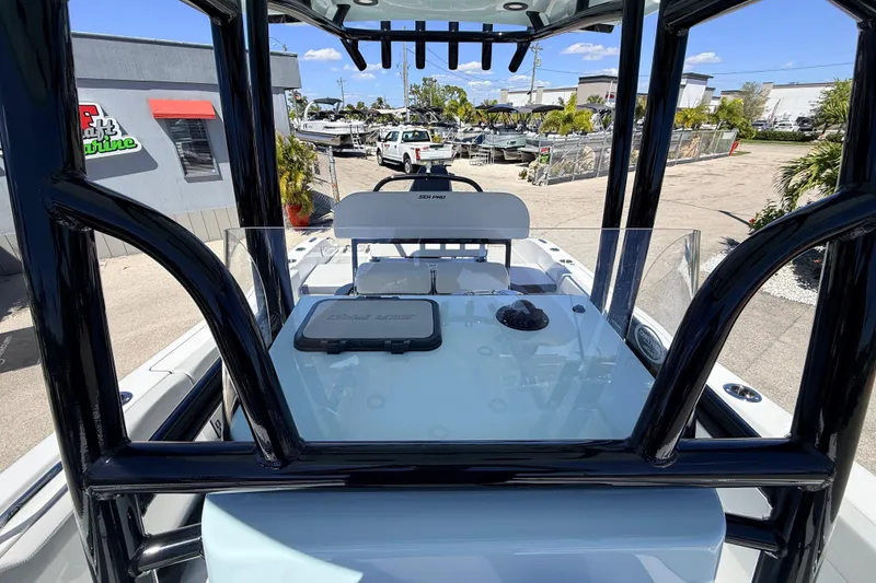 Slide: The Image of 2026 Sea Pro 225FLX Sandbar boat console with glass windshield and black frame in a marina setting. - 34