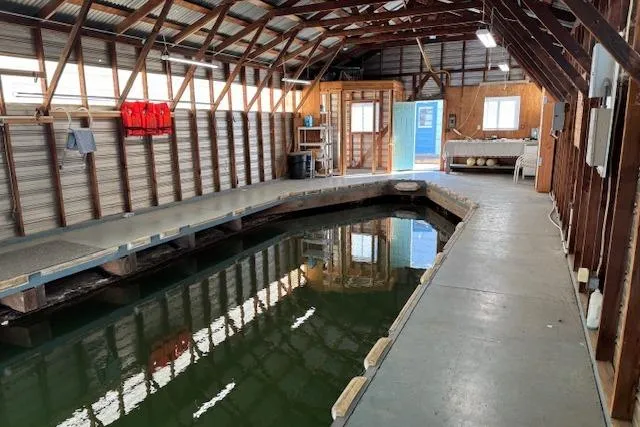 Slide: The Image of 1960 custom boathouse interior with dock, wooden beams, and water channel. - 7