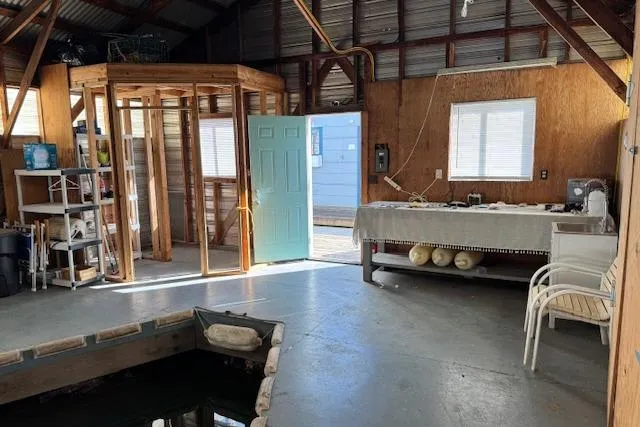 Slide: The Image of Interior of a 1960 custom boathouse with open door, dock, and storage shelves. - 8