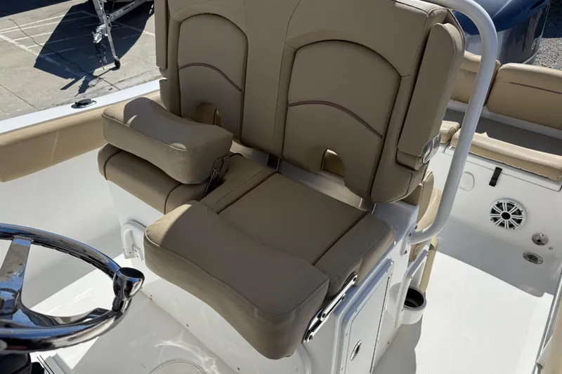 Slide: The Image of 2018 Sea Hunt Ultra 235 SE boat interior with beige seating and steering wheel. - 24
