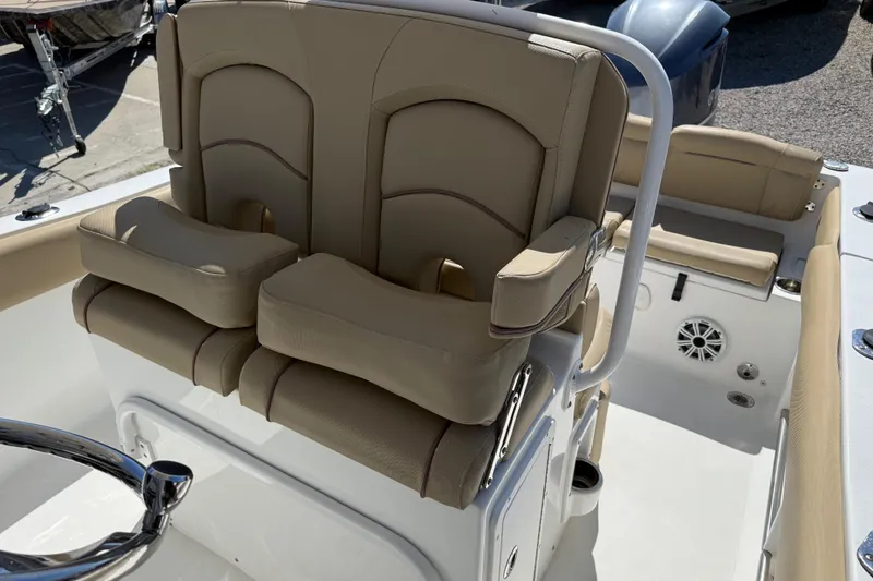 Slide: The Image of 2018 Sea Hunt Ultra 235 SE boat interior with beige seating and steering wheel. - 25