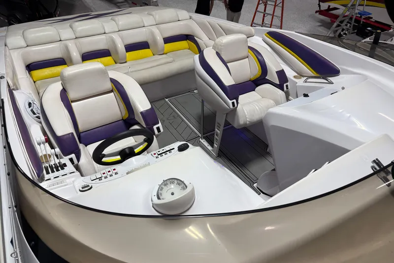 Slide: The Image of 1998 Donzi 38 ZX boat interior with white, purple, and yellow seating, and a sleek dashboard. - 11