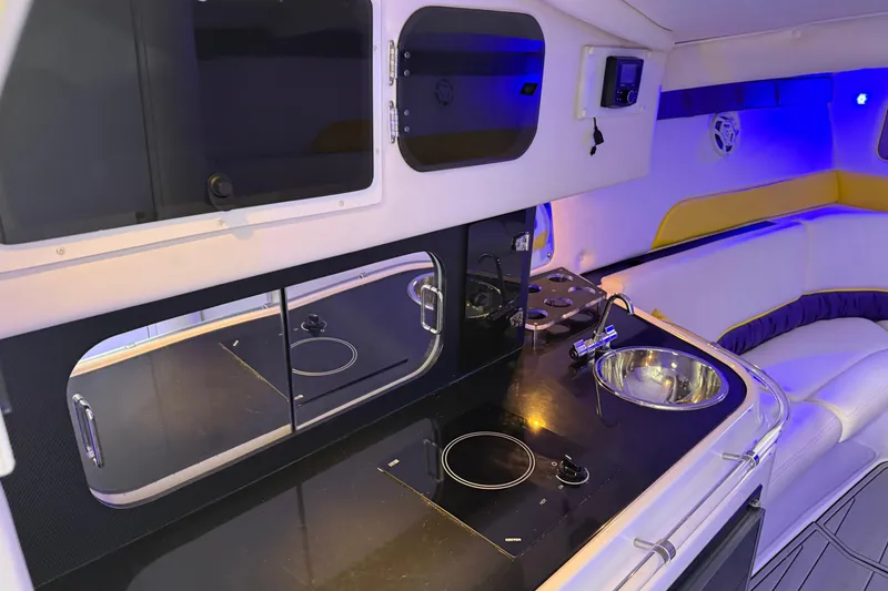 Slide: The Image of Interior of a 1998 Donzi 38 ZX boat featuring a sleek kitchenette and seating area. - 23