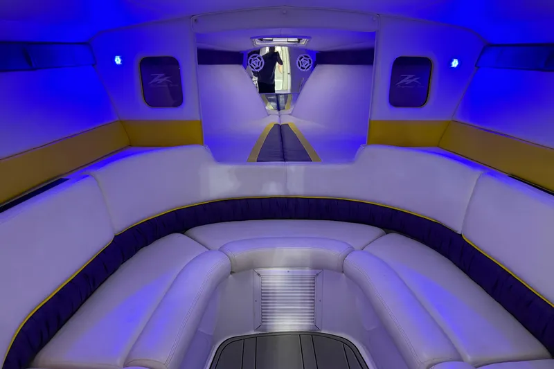 Slide: The Image of Interior of a 1998 Donzi 38 ZX boat with blue ambient lighting and plush seating. - 24