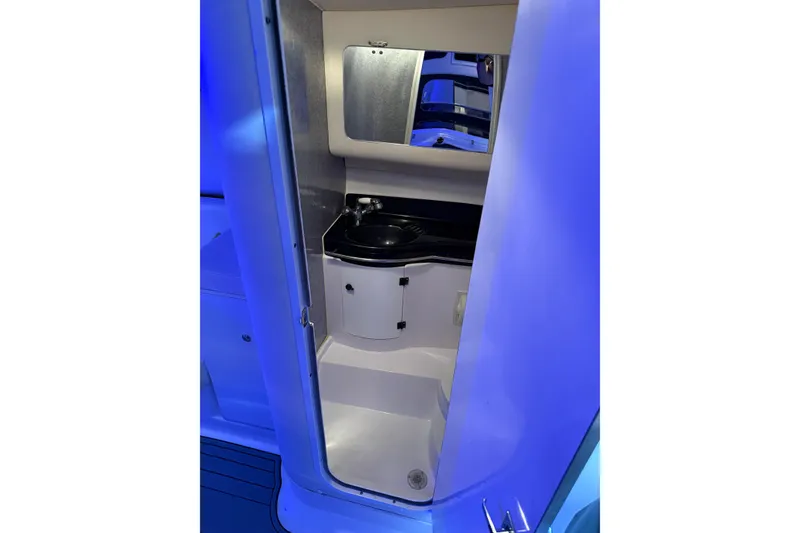 Slide: The Image of Interior of 1998 Donzi 38 ZX boat featuring a compact bathroom with sink and mirror. - 28