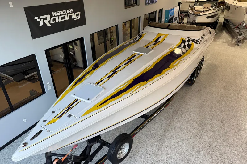 Slide: The Image of 1998 Donzi 38 ZX speedboat with vibrant yellow and purple graphics, displayed indoors. - 7