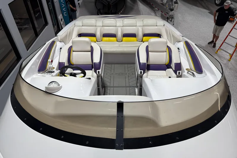 Slide: The Image of 1998 Donzi 38 ZX boat interior with purple and yellow seating, steering wheel, and dashboard. - 9