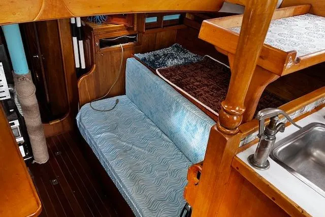 Slide: The Image of Interior of 1984 Swanson 42' Cutter with wooden cabinetry and blue cushioned seating. - 7