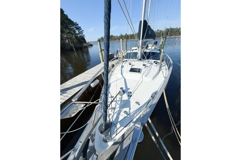 Slide: The Image of 1986 Nauticat 40 sailboat docked on calm water, surrounded by trees. - 11