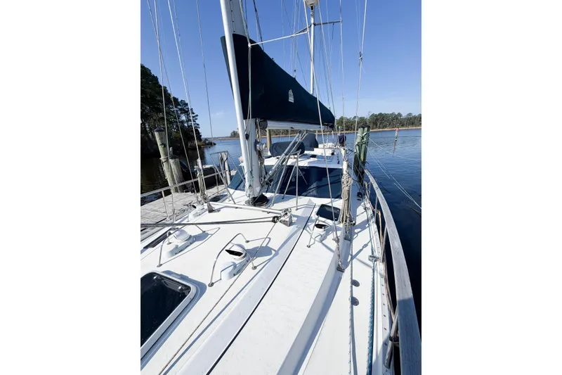 Slide: The Image of 1986 Nauticat 40 sailboat docked, showcasing deck and rigging under clear blue sky. - 12