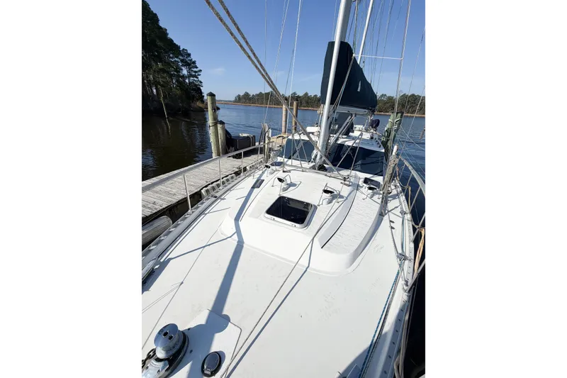 Slide: The Image of 1986 Nauticat 40 sailboat docked by a serene waterfront. - 13