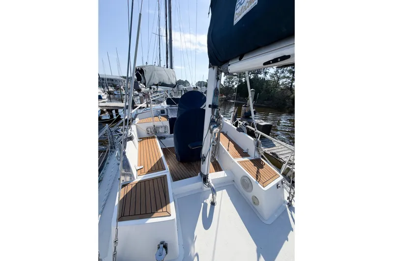 Slide: The Image of 1986 Nauticat 40 sailboat deck with wooden accents, docked in a marina. - 15