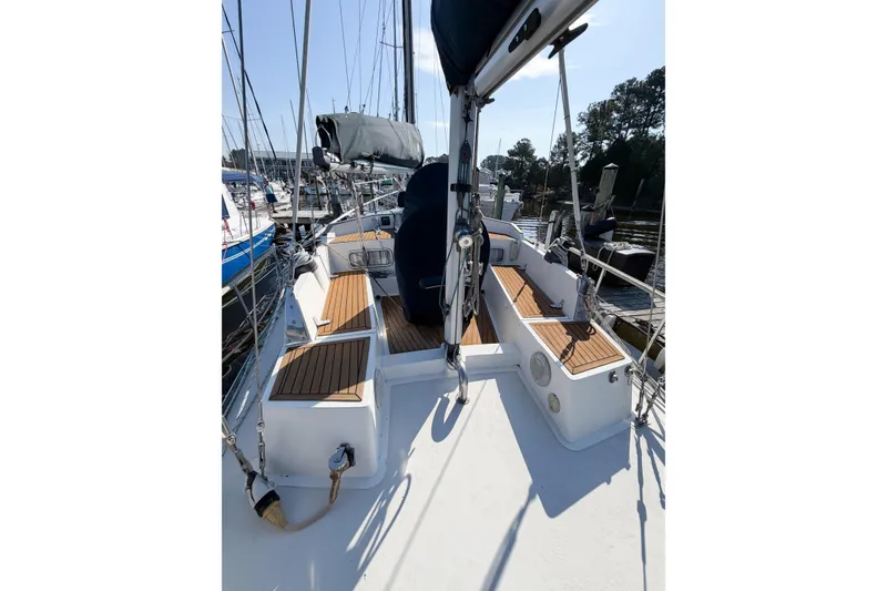 Slide: The Image of 1986 Nauticat 40 sailboat deck with wooden accents, docked at a marina. - 17