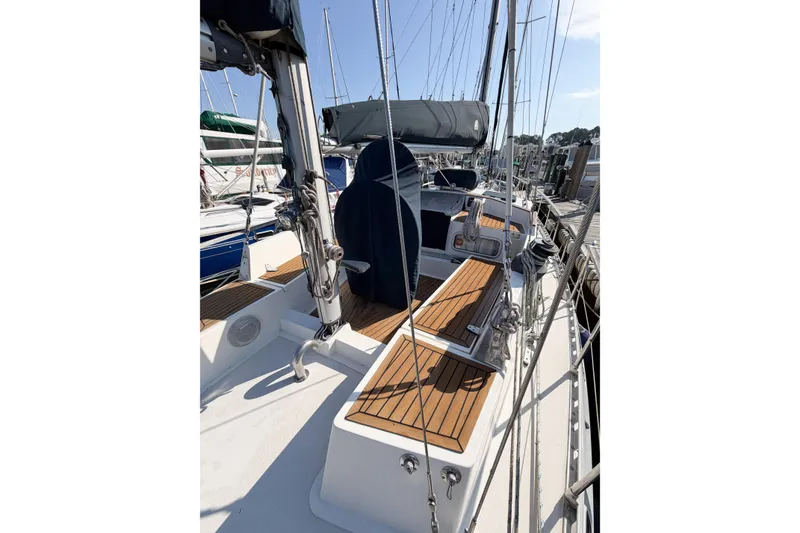 Slide: The Image of 1986 Nauticat 40 sailboat deck with wooden seating and rigging at a marina. - 18