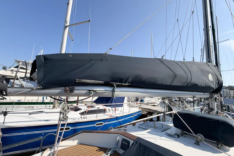 Slide: The Image of 1986 Nauticat 40 sailboat with covered boom, docked in a marina under clear blue skies. - 21