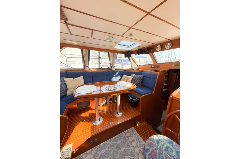 Slide: The Image of Interior of 1986 Nauticat 40 sailboat with wooden finishes and blue seating. - 30