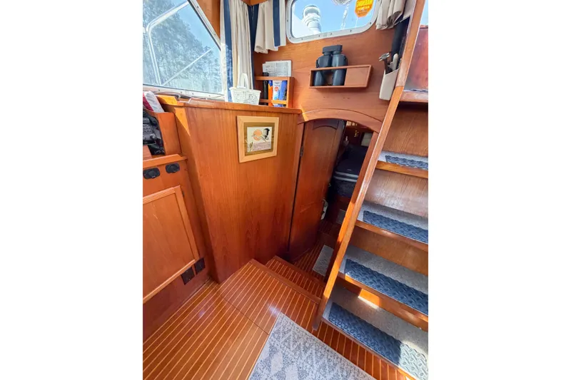 Slide: The Image of Interior of 1986 Nauticat 40 sailboat with wooden stairs and cozy cabin space. - 38