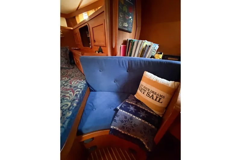 Slide: The Image of Cozy Nauticat 40 sailboat interior with blue seating and nautical-themed decor, 1986 model. - 47