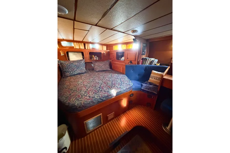 Slide: The Image of Cozy cabin interior of 1986 Nauticat 40 sailboat with bed and seating area. - 49