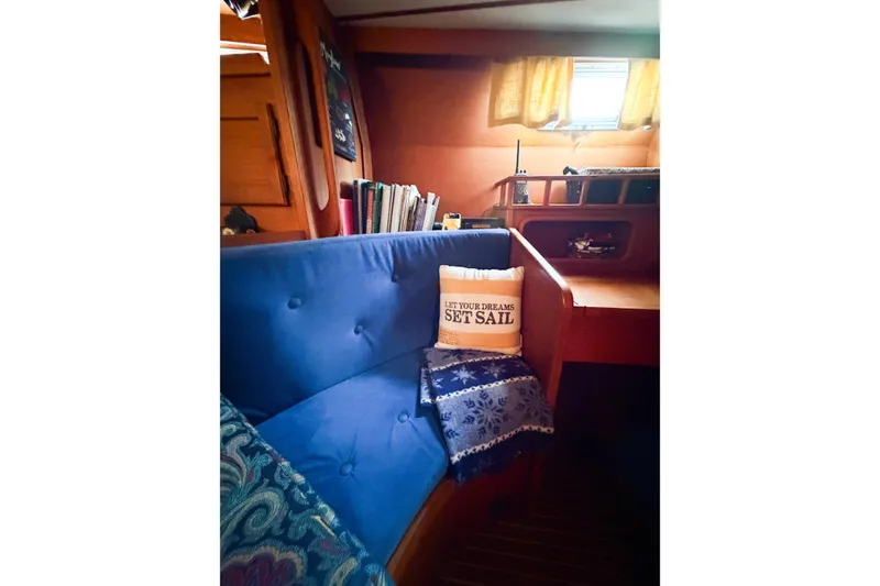 Slide: The Image of Cozy interior of 1986 Nauticat 40 sailboat with blue seating and nautical decor. - 50