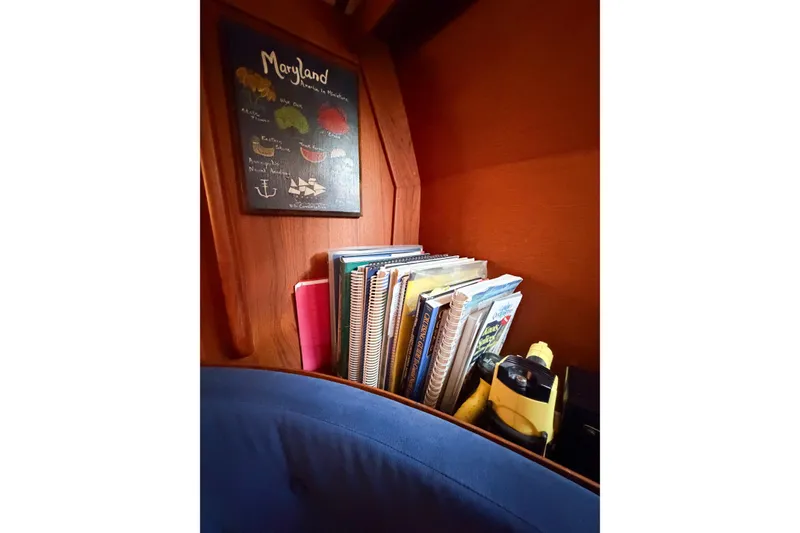 Slide: The Image of Books and a Maryland-themed sign inside a 1986 Nauticat 40 sailboat cabin. - 51
