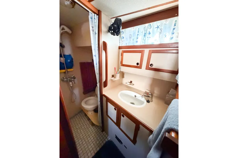 Slide: The Image of 1986 Nauticat 40 yacht bathroom with sink, shower, and storage cabinets. - 53