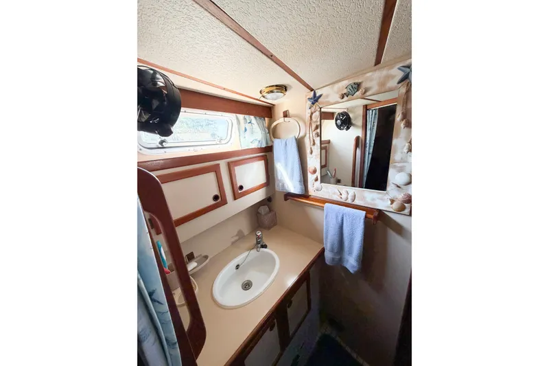Slide: The Image of 1986 Nauticat 40 yacht bathroom with sink, mirror, and nautical decor. - 55