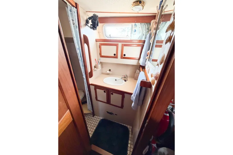 Slide: The Image of Bathroom interior of 1986 Nauticat 40 sailboat with sink, cabinets, and nautical decor. - 56