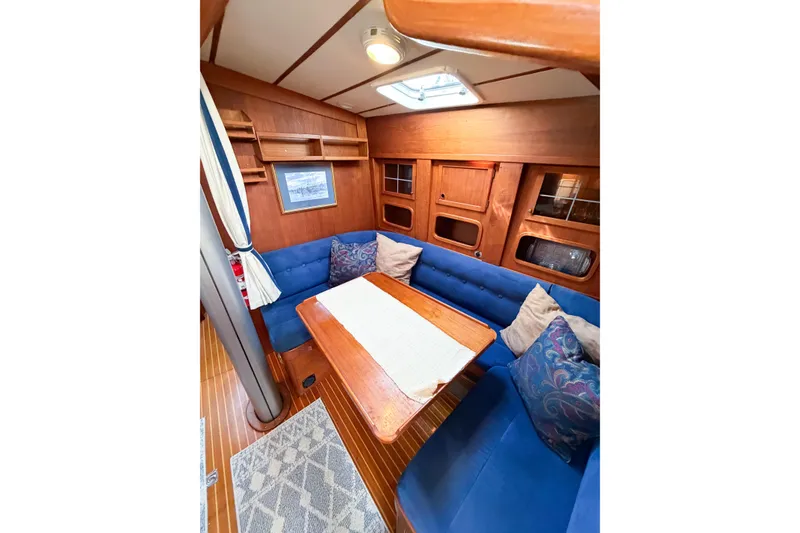 Slide: The Image of Cozy interior of 1986 Nauticat 40 sailboat with blue seating and wooden accents. - 62