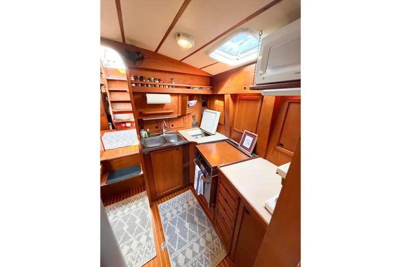 Slide: The Image of 1986 Nauticat 40 yacht interior kitchen with wooden cabinetry and skylight. - 63