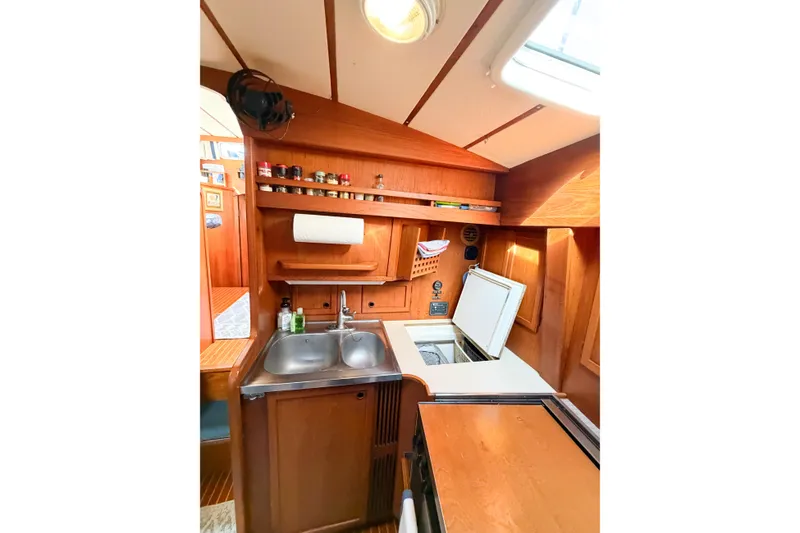 Slide: The Image of 1986 Nauticat 40 yacht interior kitchen with wooden cabinetry and dual sink. - 64