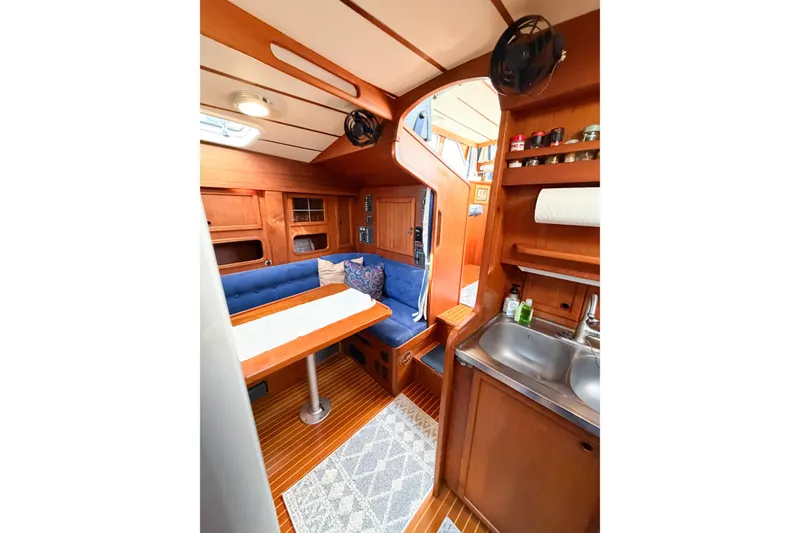 Slide: The Image of Interior of 1986 Nauticat 40 sailboat with cozy seating and compact kitchen area. - 65