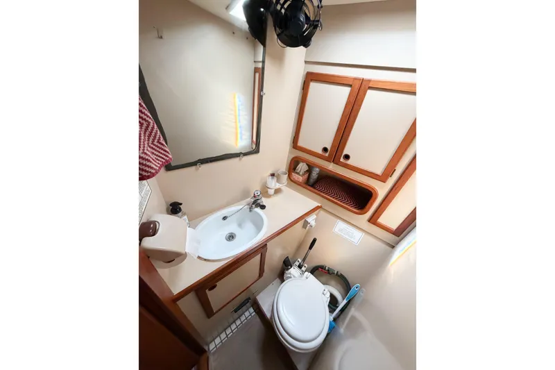 Slide: The Image of 1986 Nauticat 40 yacht bathroom with sink, mirror, and wooden cabinets. - 69