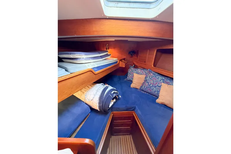 Slide: The Image of Cozy cabin interior of 1986 Nauticat 40 sailboat with blue bedding and wooden accents. - 70