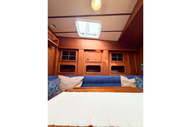 Slide: The Image of Interior of 1986 Nauticat 40 sailboat with wooden cabinetry and blue seating. - 80