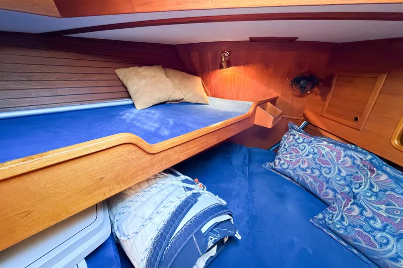 Slide: The Image of Cozy cabin interior of 1986 Nauticat 40 sailboat with blue bedding and wooden accents. - 82