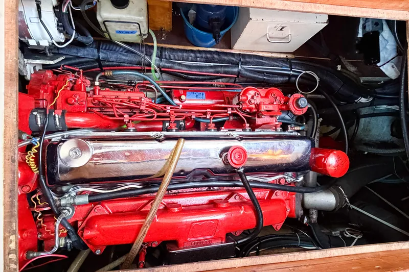 Slide: The Image of Engine compartment of a 1986 Nauticat 40 sailboat, featuring a red marine engine. - 83