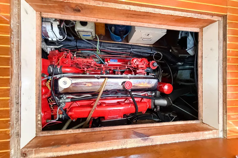 Slide: The Image of Engine compartment of a 1986 Nauticat 40 sailboat, showcasing a red marine engine. - 84