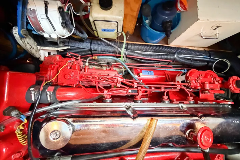 Slide: The Image of Engine compartment of a 1986 Nauticat 40 sailboat, featuring red mechanical components. - 85