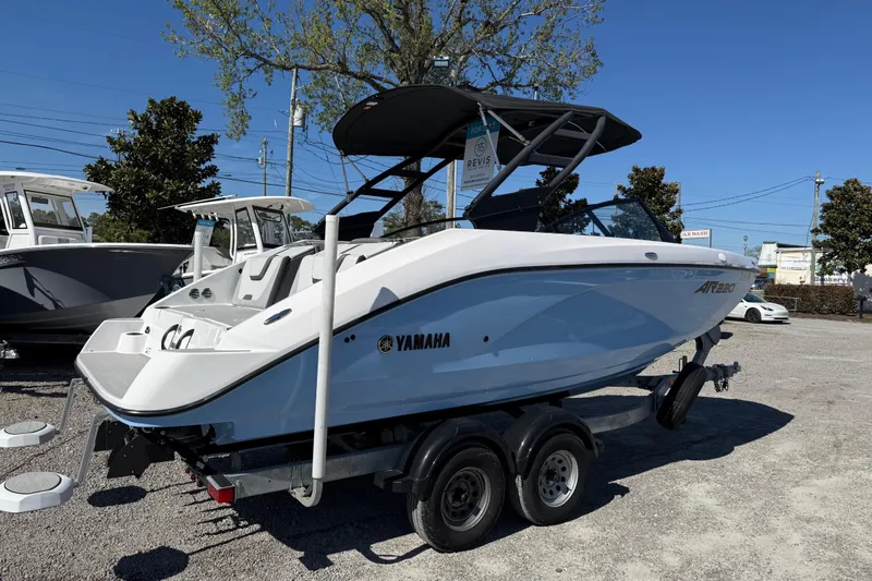 Slide: The Image of 2024 Yamaha Boats AR220 on trailer, displayed outdoors under clear blue sky. - 12