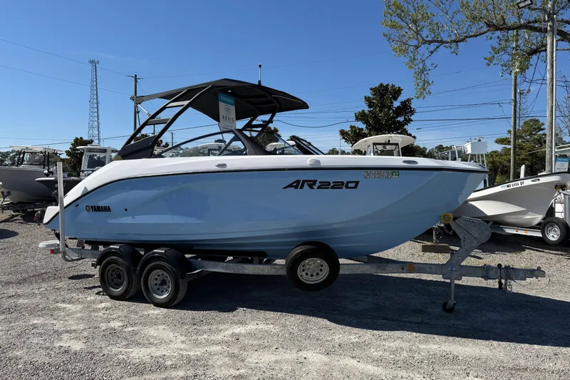 Slide: The Image of 2024 Yamaha Boats AR220 on trailer, displayed outdoors under clear blue sky. - 14