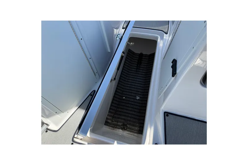 Slide: The Image of 2024 Yamaha Boats AR220 storage compartment with open hatch and non-slip mat. - 26
