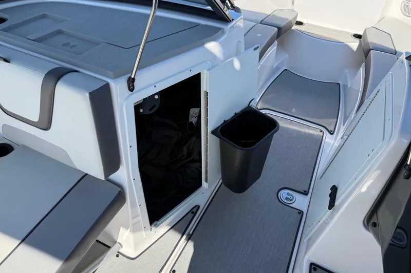 Slide: The Image of 2024 Yamaha Boats AR220 interior storage and seating area with open compartment. - 27