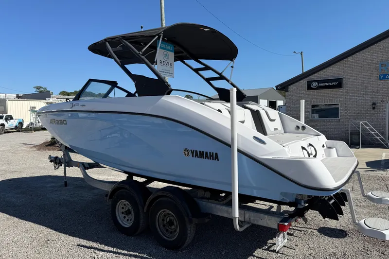 Slide: The Image of 2024 Yamaha Boats AR220 on trailer, displayed outdoors near a building. - 3