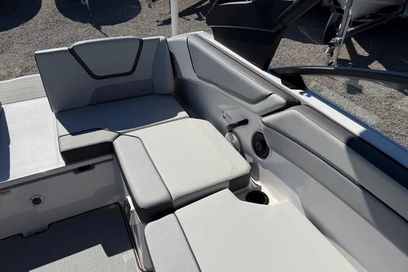 Slide: The Image of 2024 Yamaha Boats AR220 interior seating with gray upholstery and cup holder. - 30